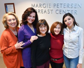 Five women in front of the Margie Petersen Breast Center sign