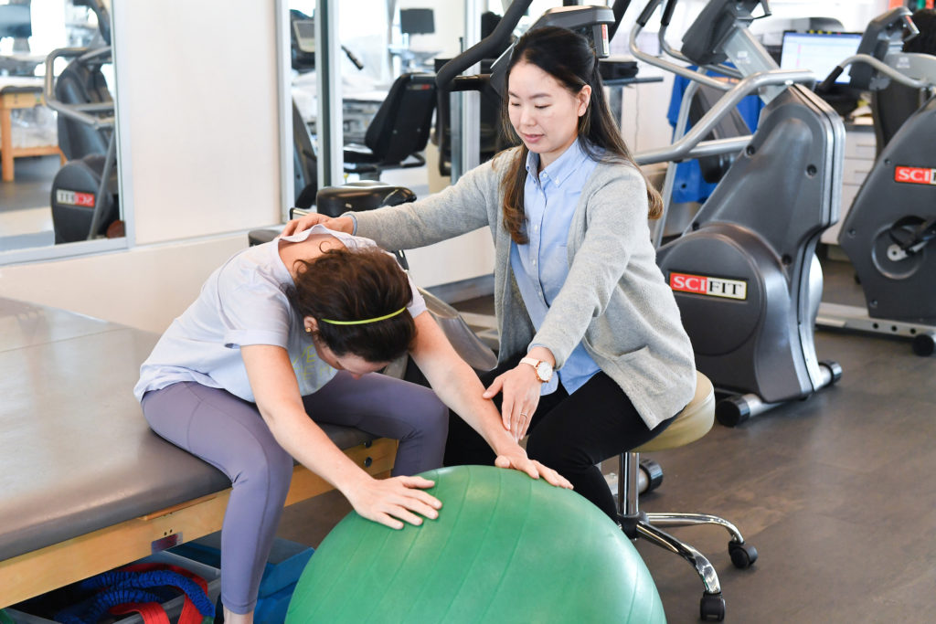 doctor working with patient through physical therapy